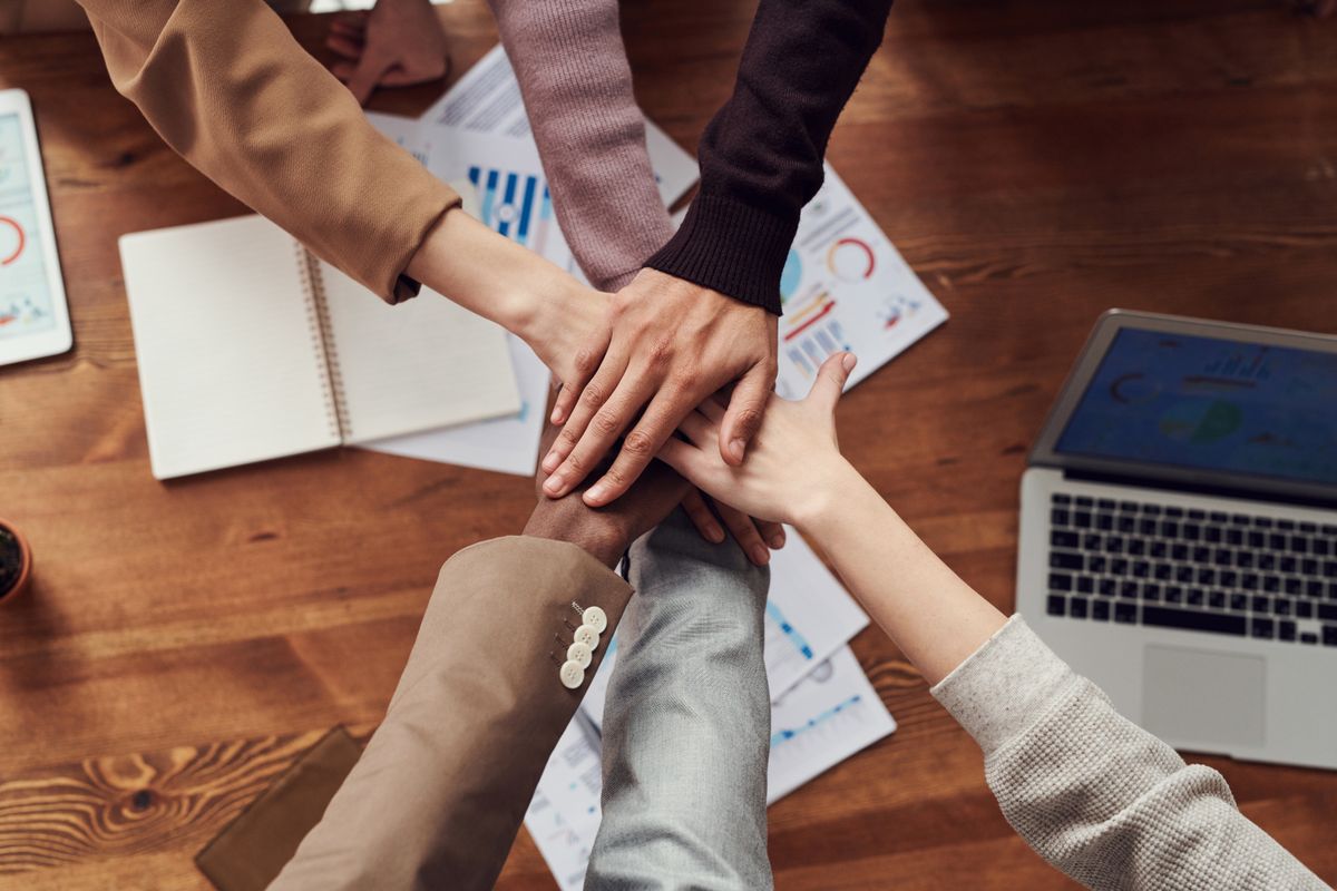 Team members placing their hands together