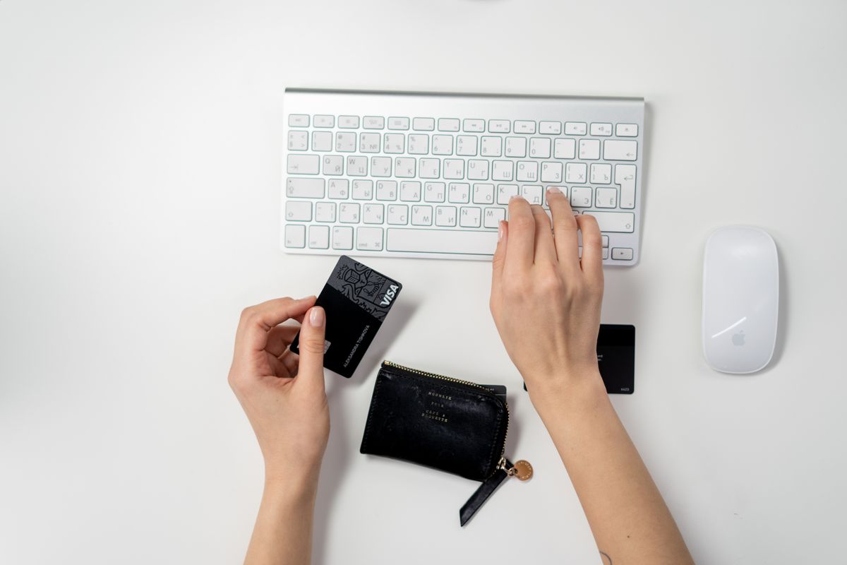 A laptop, payment card and wallet on a desk