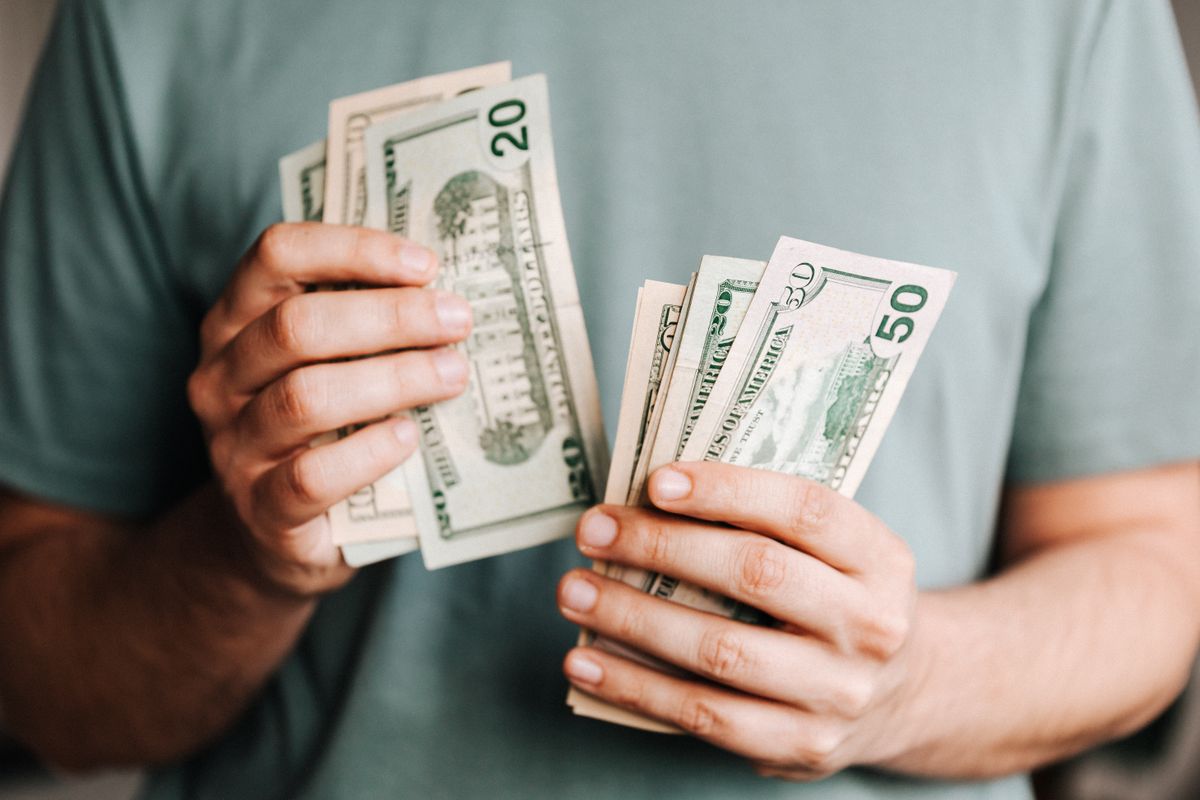 A person holding paper currency