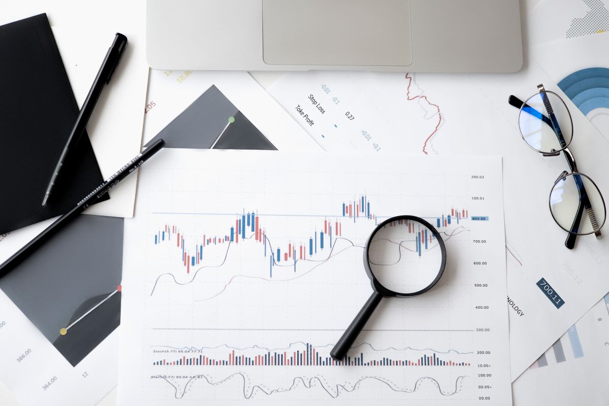 A magnifying glass beside financial charts